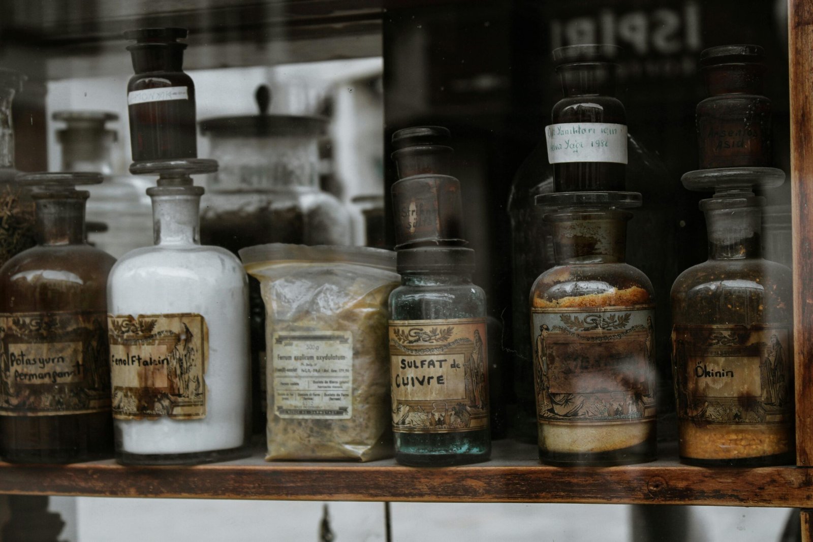 project-2 Collection of vintage apothecary bottles with handwritten labels on a wooden shelf, reflecting a medieval charm.